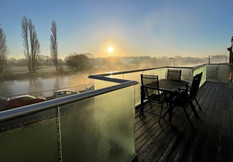 Early morning mist envelopes angled glass balcony